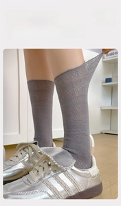 Detail of grey mesh lace calf socks with elastic cuffs paired with silver vintage shoes
