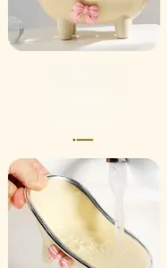 Detail of cream bathtub soap dish with pink bow being rinsed under clean water flow