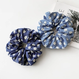 Denim hair scrunchies with white floral embroidery in light and dark blue tones