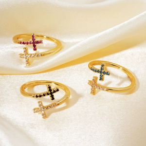 Detailed close-up of three gold-plated cross rings with colorful cubic zirconia stones