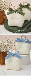 Detail of elegant Chinese wedding gift boxes with wooden ring handles and satin ribbons