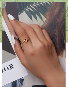 Close-up of gold plated 925 sterling silver hugging hands ring on model's finger