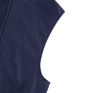 Dettaglio ravvicinato delle cuciture e della trama di lino su una camicia blu scuro senza maniche