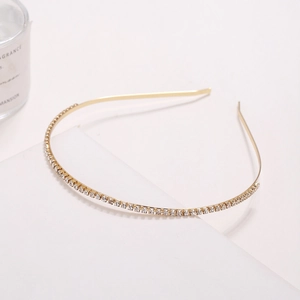 Minimalist gold metal headband with sparkling clear rhinestones on white display