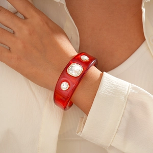 Detailed shot of a red resin cuff bracelet with square crystal and pavé rhinestones