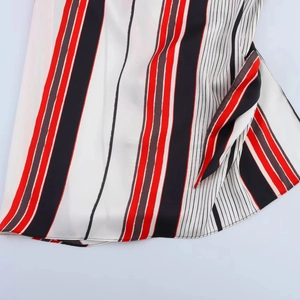 Macro detail of asymmetric hemline featuring red, black and white vertical stripes fabric