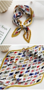 Detail of pleated silk-like scarf with yellow edges and cute cartoon cat pattern