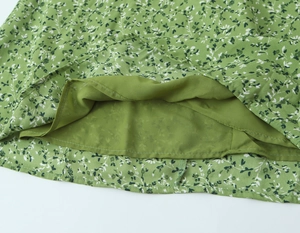 Détail du tissu à fleurs vert clair avec des coutures soignées et une doublure en polyester