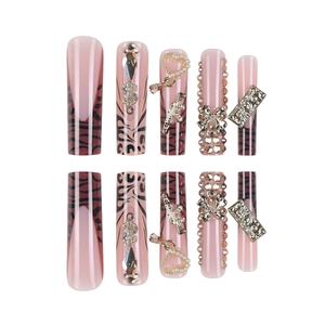 Faux ongles dorés de luxe avec imprimé léopard, strass et nœuds papillon ornés