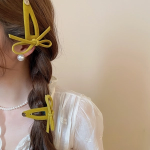 Close-up of mustard yellow flocked velvet bow hair clip with Smile Happy metal bead detail
