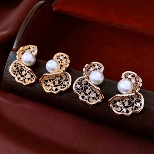 Detailed macro view of 18K gold plated lace flower earrings with white pearl and zircons