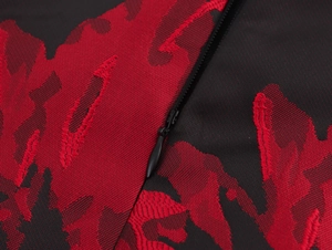 Close-up of red floral jacquard fabric and hidden zipper detail on the halter dress