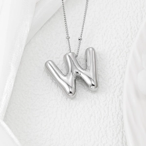 Detail shot of the 3D silver bubble letter W pendant on a beaded silver chain