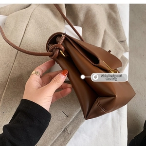 Détail de la conception latérale multicouche et du cuir marron texturé de ce sac bandoulière