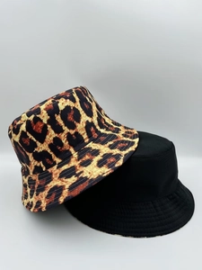 Detail showing reversible leopard print and solid black bucket hats in cotton canvas