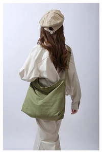 Borsa a tracolla in tela di cotone lavato verde indossata da una modella stile vintage
