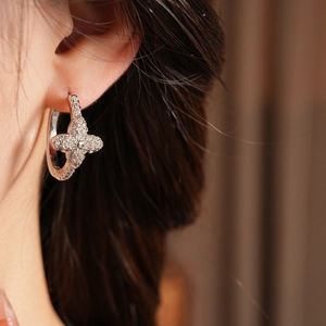 Detailed close-up of a silver four-leaf clover earring with sparkling cubic zirconia stones