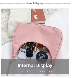 Flat lay showing internal capacity of the pink nylon crescent hobo bag with essentials