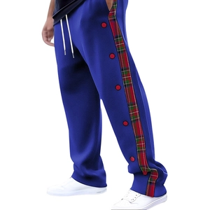 Detail of blue men's joggers with red-green plaid side stripes and red decorative buttons