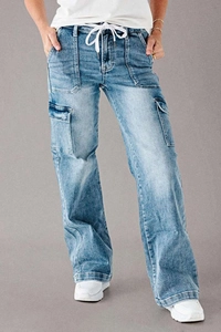 Detail of light blue denim cargo pants showing white drawstring and large side utility pockets