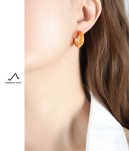 Detail view of a vibrant orange enamel hoop earring crafted in durable stainless steel