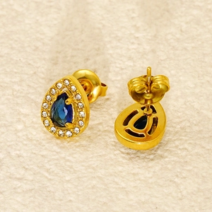 Detailed view of gold teardrop earrings with dark blue stone and zircon accents