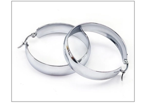 Close-up of polished silver wide stainless steel hoop earrings with snap-lock closure