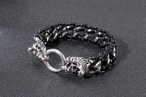 Detail of woven leather bracelet featuring dual silver tiger head clasps and ring buckle