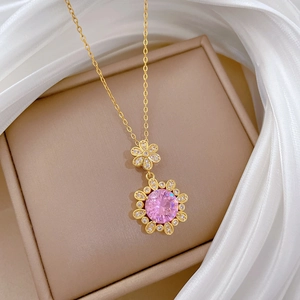 Close-up of pink crystal flower pendant necklace on elegant beige jewelry box display