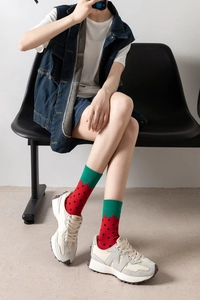 Close-up of cotton socks with vibrant strawberry pattern and green trim details