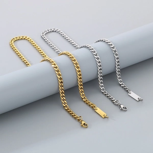 Detail of 18K gold and silver stainless steel Cuban link bracelets with rectangular tags