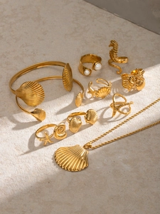Vue détaillée de l'ensemble de bijoux océaniques dorés 18 carats avec coquillages et étoiles