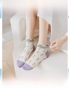 Detailed close-up of floral jacquard socks with green ruffled cuffs and purple accents