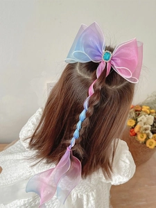 Detail of pink and blue gradient bow hair clip with ribbons and blue gem center