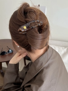 Detail of tortoise shell resin hair clip with gold fashion buckle on a model