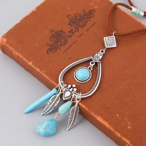 Detail view of Bohemian silver necklace featuring turquoise pendant and metallic feathers