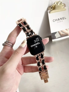 Detail of rose gold metal chain watch strap with black woven leather for Apple Watch