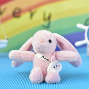 Close-up of a cute pink plush rabbit doll pendant featuring a decorative Just for ribbon