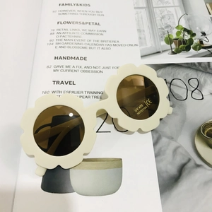 Detail of flower-shaped kids sunglasses in cream white with UV400 protective lenses