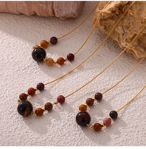 Detail showing natural tiger eye stone beads and gold titanium steel chain necklace