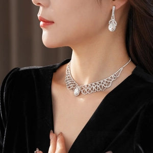 Close-up of teardrop diamond jewelry set including hollow necklace and stud earrings