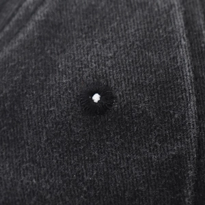 Close-up of the dark grey washed cotton fabric and precise stitched ventilation eyelet