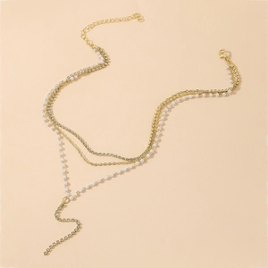 Detailed view of triple-layered gold chain with pearls, rhinestones and lobster clasp