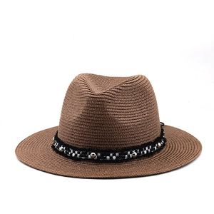 Detailed texture of brown straw fedora featuring a checkered band with metallic beads