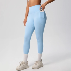 Close-up of high-waist light blue yoga pants showing the side pocket with a phone