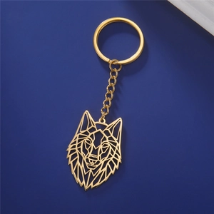 Detailed close-up of a golden geometric wolf head pendant on a stainless steel keychain