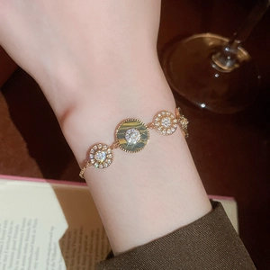 Detailansicht eines 18K vergoldeten Armbands mit Tigerauge und Zirkon am Handgelenk