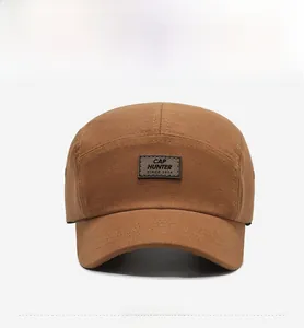 Dettaglio ravvicinato del cappellino a 5 pannelli cammello con patch in pelle premium