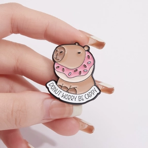 Cute capybara enamel pin with pink donut and funny Donut Worry Be Cappy text