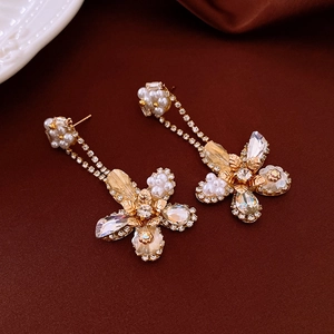 Elegant gold-tone flower earrings with white pearls and sparkling crystal tassels